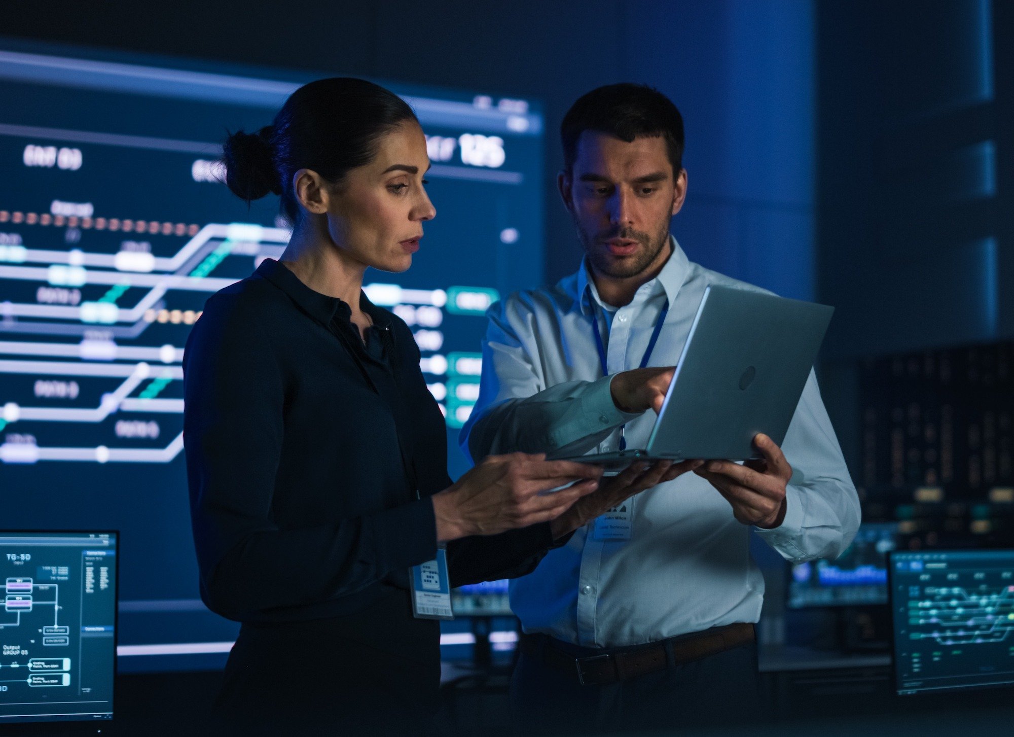 Two people in a data center looking at a laptop